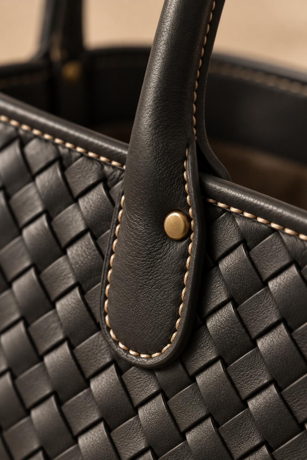 Hand stitched edge and brass rivet on the Wren black woven leather tote