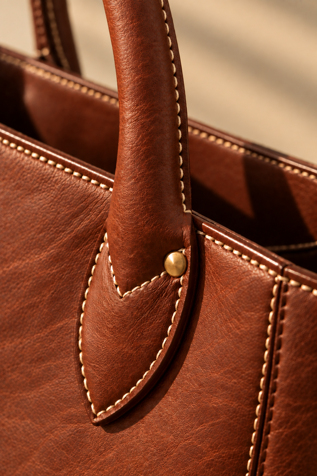 Hand stitched edge and brass rivet on the Marlow chestnut leather tote bag