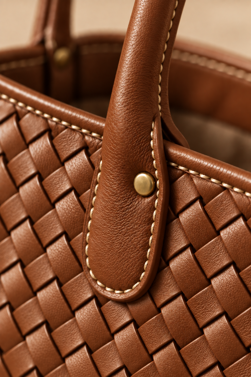 Hand stitched edge and brass rivet on the Wren cognac woven leather tote