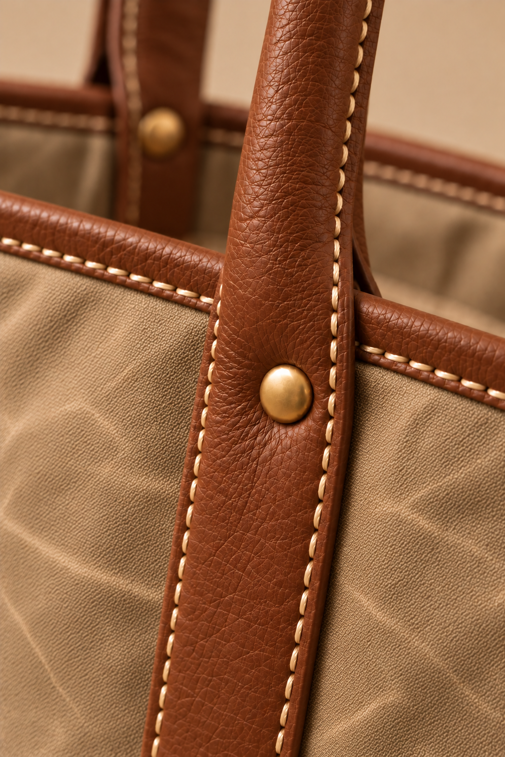 Hand stitched edge and brass rivet on the Ellis sand & cognac canvas and leather tote
